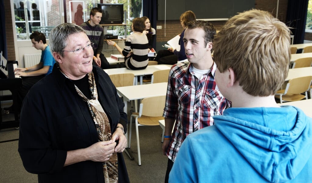 Els van Dijk, directeur van de Evangelische Hogeschool in Amersfoort, in gesprek met een aantal studenten. (beeld Dick Vos)