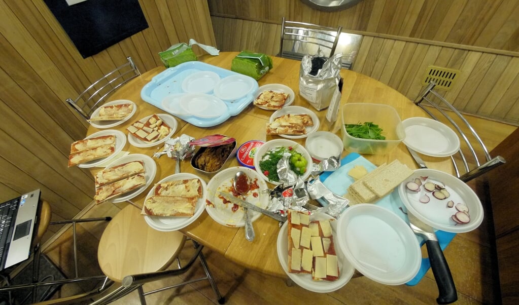 Op 3 juni 2011 aten de vrijwilligers van Mars500 'Martiaanse pizza's' om te vieren dat ze een jaar in isolatie zaten. 'Bij de dag leven helpt', aldus Charles Romain. (beeld afp / esa)