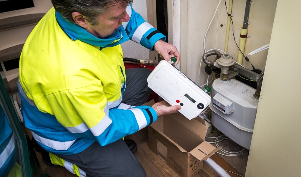 Een monteur installeert een slimme gasmeter. Wil je van het gas af, dan worden gasaansluiting en meter verwijderd, de rekening gaat naar de gasverlater. (beeld anp / Lex van Lieshout)