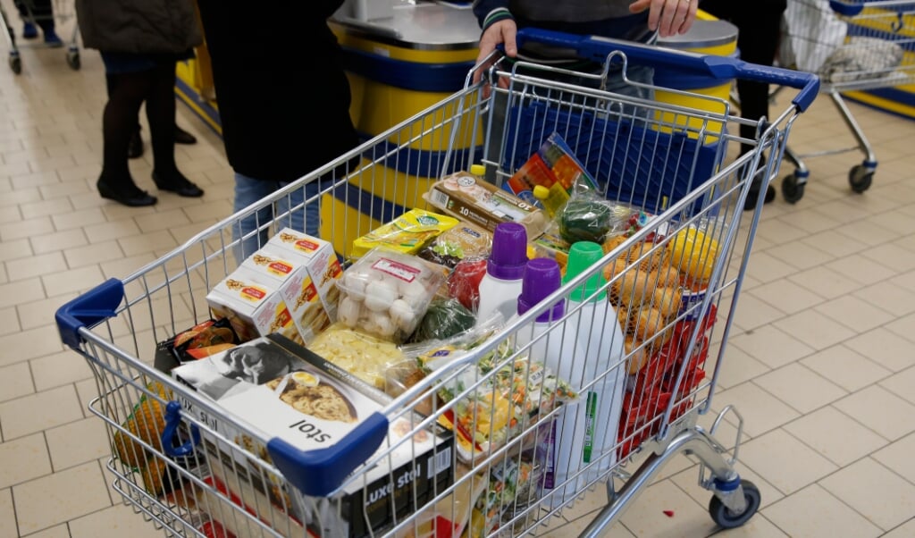 <p>HUIZEN - Een winkelwagen vol boodschappen bij de kassa van supermarkt Lidl, daags voor Kerst. ANP BAS CZERWINSKI</p> (beeld Hollandse Hoogte / anp)