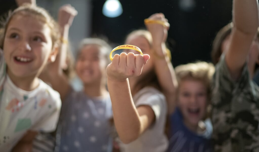 Kinderen tonen een antipestbandje tijdens de aftrap van de Week Tegen Pesten. (beeld anp / Jasper Juinen en Tessa Posthuma de Boer)