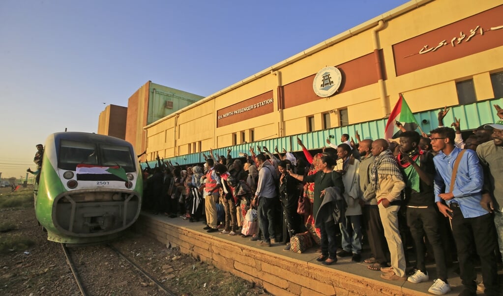 Sudanezen wachten op de trein die hen naar Atbara zal brengen, voor een feestelijke herdenking van de protesten van vorig jaar. ( beeld afp / Ashraf Shazly)