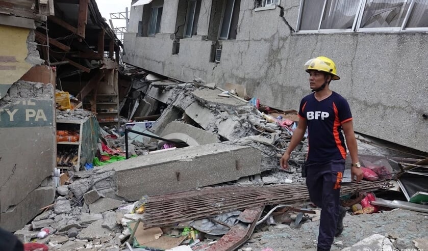 2019-12-15 16:28:06 epa08073059 A fireman inspects a damaged market in the quake-hit town of Padada, Davao Del Sur province, Philippines, 15 December 2019. , An earthquake of magnitude 6.8 shook the island of Mindanao in southern Philippines on December ( beeld anp)