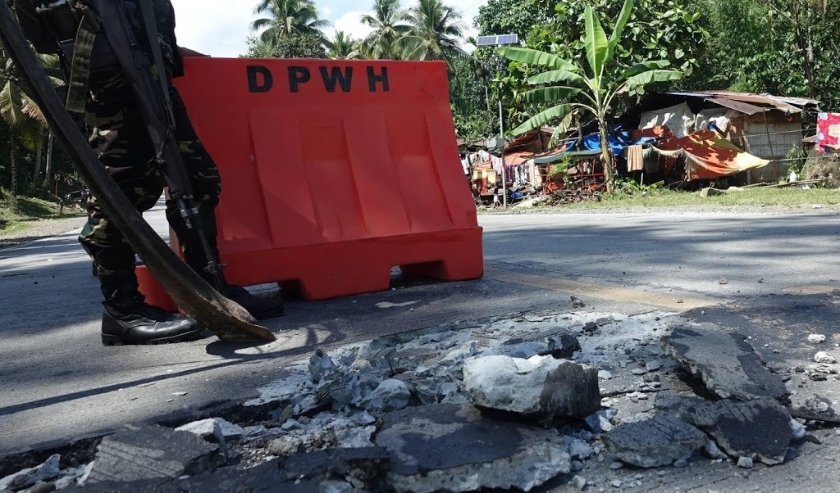 2019-10-31 11:30:48 epa07962195 A Filipino soldier stands guard at a damaged road in the aftermath of a 6.5 magnitude earthquake, in the town of Malasila, Cotabato province, Philippines, 31 October 2019. According to the United States Geological Survey (U ( beeld anp)