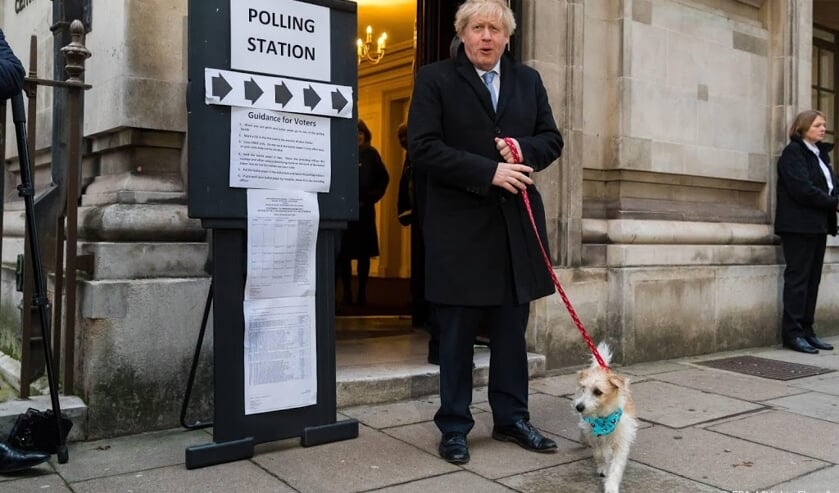 2019-12-12 09:19:44 epa08064423 Britain's Prime Minster Boris Johnson leaves a polling station after casting his vote with his dog Dylan at a polling station in London, Britain, 12 December 2019. Britons go to the polls on 12 December 2019 in a general el ( beeld anp)