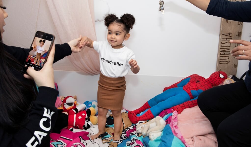 Quenisha is twee jaar en heeft op Instagram minstens 369.000 volgers. Ze heeft zelfs haar eigen boekingsagent en staat ingeschreven bij kindermodellenbureau Kidz Management. Sunisa (30), de moeder van Quenisha, maakt vrijwel dagelijks nieuwe foto’s, terwi (beeld Martijn van de Griendt / Document Nederland)