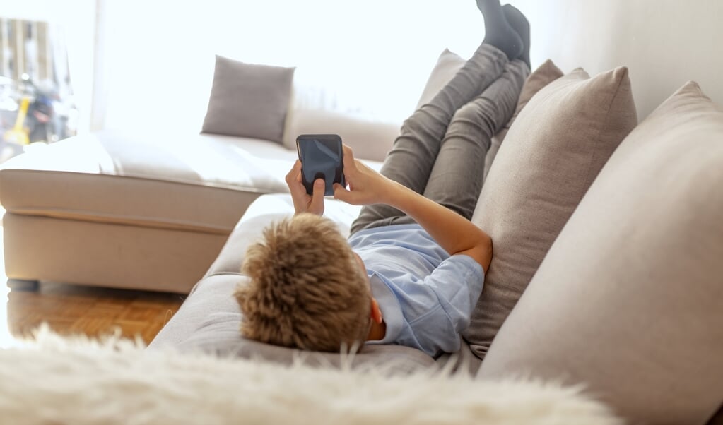 Ouders vinden al snel dat hun kind zijn tijd verdoet als het te lang met zijn vrienden aan het appen is of uren ligt te ‘niksen’. (beeld istock)