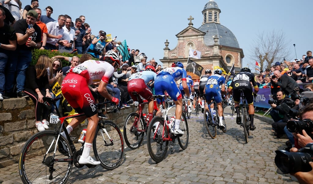 <p>Het peloton in actie op de Kapelmuur tijdens de Ronde van Vlaanderen in 2019. </p> (beeld anp / Bas Czerwinski)