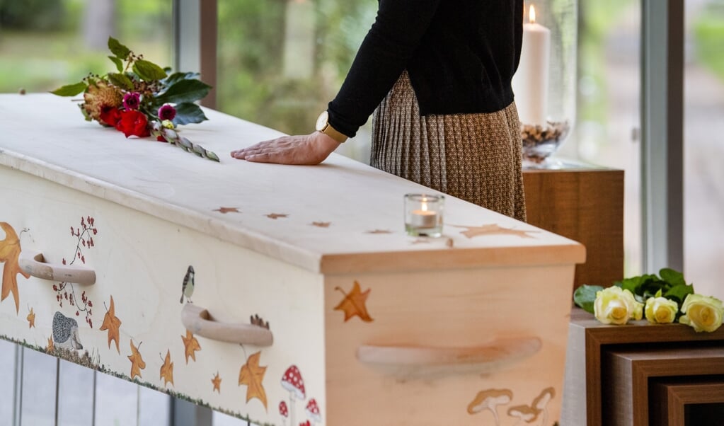 Nabestaande neemt afscheid bij de doodskist van een overledene in een uitvaartcentrum. (beeld anp / Xtra Piroschka van de Wouw)