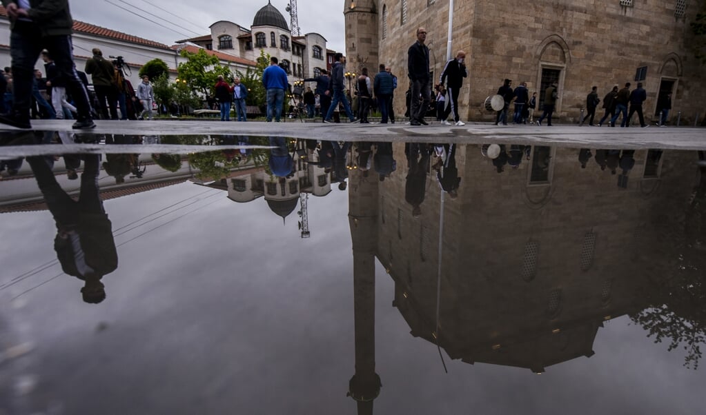 Moslims bij de grote moskee van de Kosovaarse stad Pristina. De overheid heeft imams gevraagd mee te werken aan deradicalisering van ISIS-strijders die in de gevangenis zitten. ( beeld AFP)