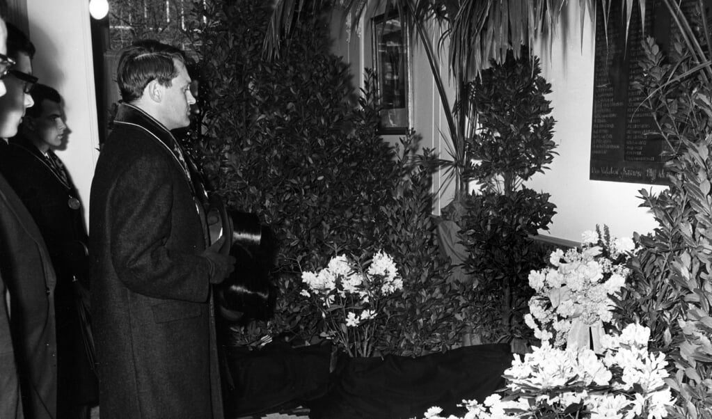 Rector R.W. Dijk van het studentencorps van de Vrije Universiteit gedenkt op 4 mei 1965 de gevallenen, bij de gedenkplaat in de hal van het VU-gebouw aan de Keizersgracht. (beeld fotocollectie universiteitsbibliotheek vu)