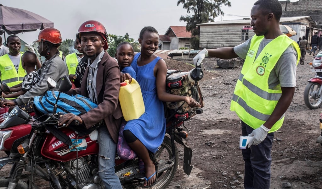 In Oost-Congo heerst al anderhalf jaar een ebola-epidemie. Hier spuit een gezondheidsmedewerker een desinfecterend middel in de hand van de vrouw, na het controleren van haar temperatuur. Een ebolabestrijder zegt dat de maatregelen die de bevolking neemt tegen ebola, ook beschermen tegen het coronavirus. (beeld Epa/patricia Martinez)