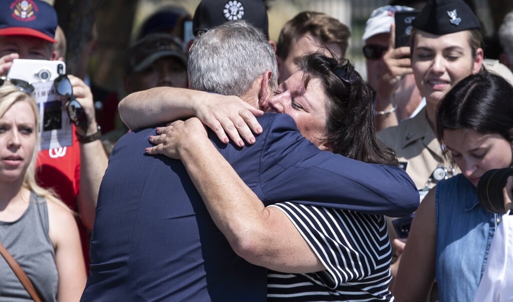 Oud-president George W. Bush wordt omhelsd door Lisa Dolan, weduwe van de bij de aanslagen van 9/11 omgekomen kapitein Robert Dolan. Bush riep de Amerikanen op, nu in de coronacrisis net als toen vereend te zijn. (beeld Epa/michael Reynolds)
