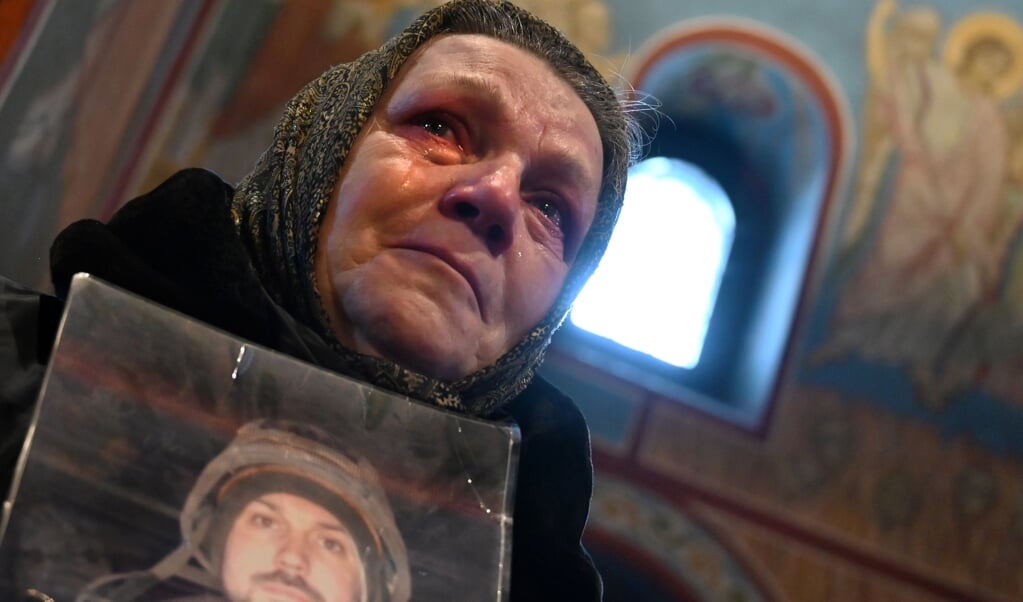 Een Oekraïense moeder houdt een portret van haar zoon vast. Hij was een van de 'cyborgs' en kwam om tijdens de gevechten tegen de rebellen op het vliegveld van Donetsk. (beeld afp / Sergei Supinsky)