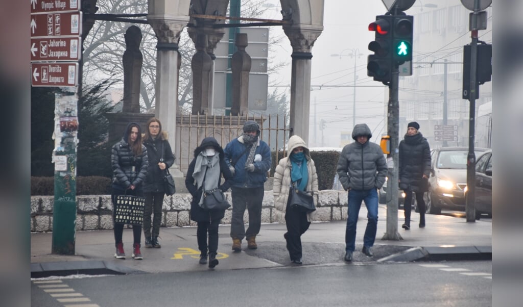 Inwoners van Sarajevo met en zonder mondkapjes of met een sjaal voor het gezicht. (beeld Marjolein Koster)