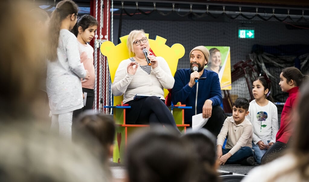 Kinderboekenambassadeur Manon Sikkel en Abdelkader Benali tijdens de start van de tiende editie van De Schoolschrijver, een landelijke actie ter bevordering van de lees- en schrijfvaardigheid van leerlingen. (beeld Freek van den Bergh)