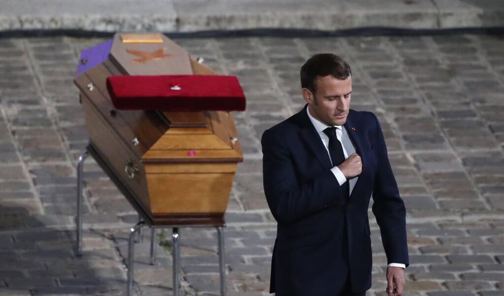 De Franse president Emmanuel Macron brengt hulde aan de onthoofde leraar Samuel Paty. (beeld afp / Francois Mori)