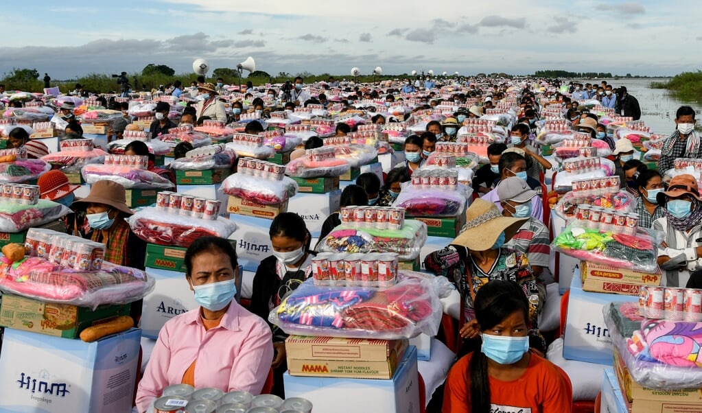 <p>Overlevenden van overstromingen in de Cambodjaanse provincie Banteay Meanchey ontvangen op 21 oktober noodhulp namens president Hun Sen.<em> </em></p> (beeld str / afp)