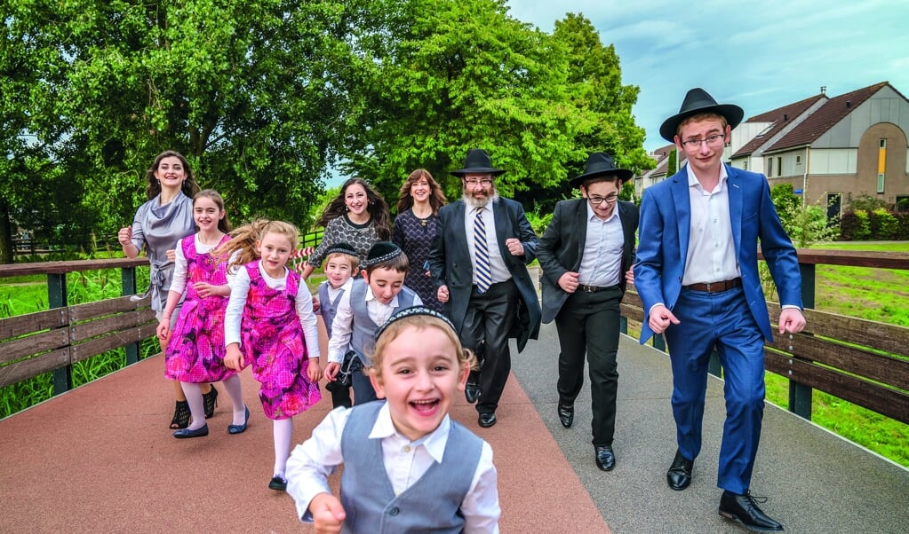 <p>Fam. Stiefel (negen kinderen): Channa (1975) en Moshe (1972) met Mussi (1998), Sorele (1999), Mendy (2001), Meirke (2003), Menuchele (2005), Gitty (2007), Levi (2009), Yossie (2011) en Leibele (2013).</p> (beeld Claudia Kamergorodski)