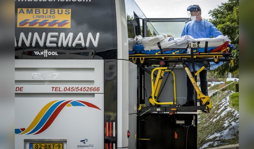 <p>Een speciale ambulancebus met zes coronapatiënten komt aan bij academisch ziekenhuis Maastricht UMC+. De patiënten zijn afkomstig uit Rotterdam.</p> (beeld anp / Marcel van Hoorn)