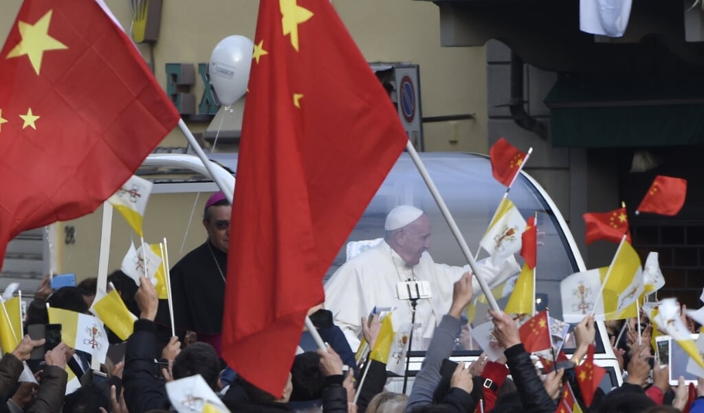 <p>Katholieke gelovigen zwaaien in Prato, een plaats bij Florence (Italië) waar veel Chinese immigranten wonen, met Chinese vlaggen. Franciscus bezocht de plaats in november 2015.</p> (beeld Andreas Solaro / afp)
