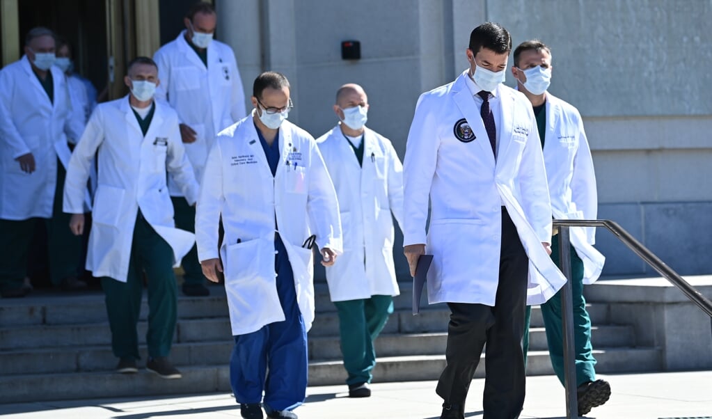 <p>De medische staf van Donald Trump, vlak voordat dat de artsen zaterdagmiddag een update over diens gezondheid gaven.</p> (beeld Brendan Smialowski / afp)