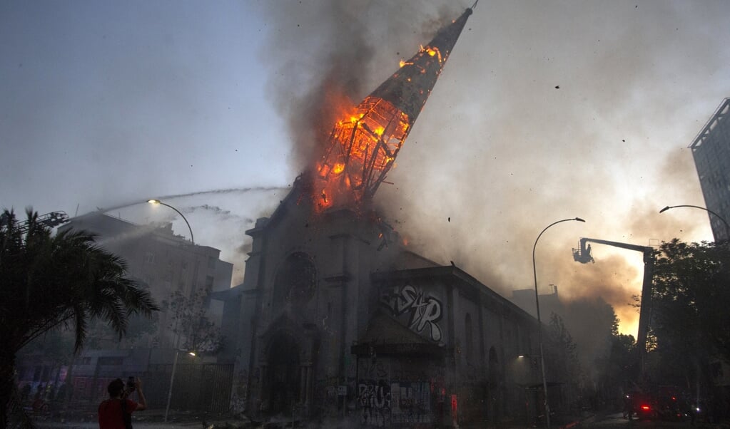 <p>Het beeld van de brandende kerktoren die instortte, ging de wereld over.</p> (beeld afp / Claudio Reyes)