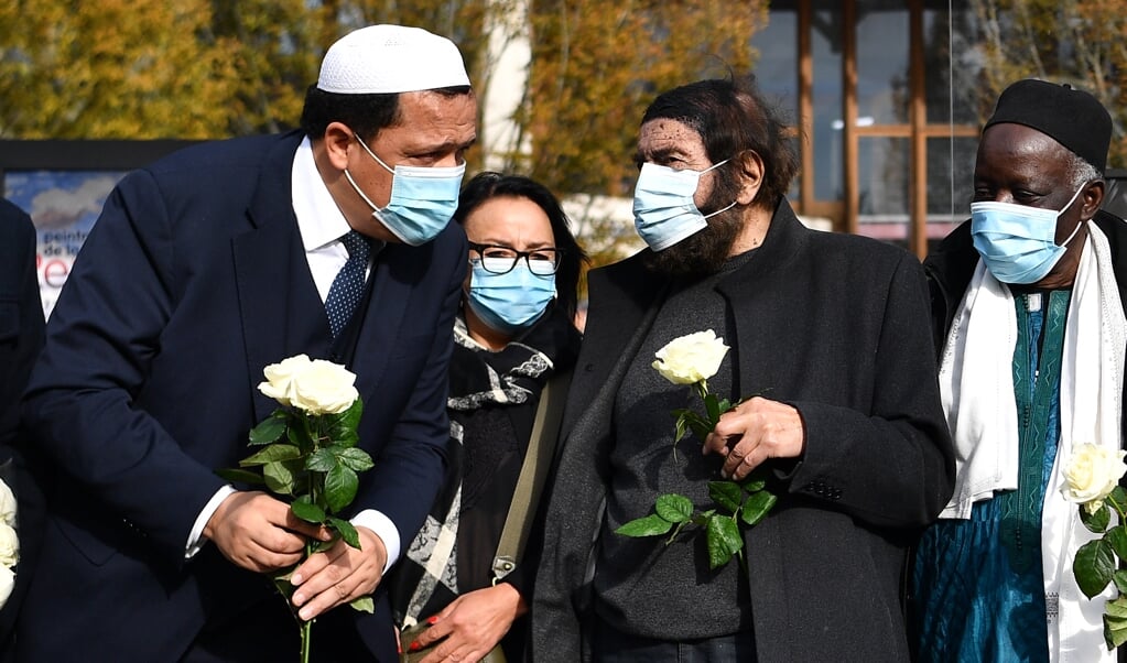 <p>Hassen Chalghoumi, imam in Drancy en de joodse schrijver Marek Halter bij de Bois d'Aulne-school waarvan de leraar Samuel Paty werd onthoofd.</p> (beeld afp / Anne-Christine Poujoulat)
