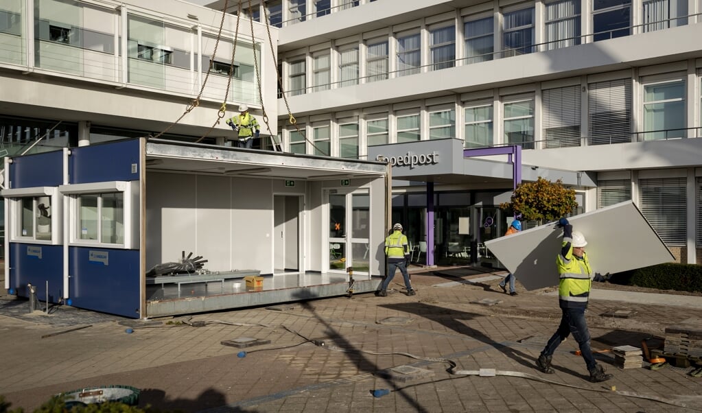 <p>Bij het Sint Jans Gasthuis in Weert zijn dinsdag zeven noodgebouwen bij de hoofdingang van het ziekenhuis opgezet. Hiermee loopt het ziekenhuis vooruit op de verwachte opvang van grotere aantallen coronapatiënten.</p> (beeld anp / Robin van Lonkhuijsen)