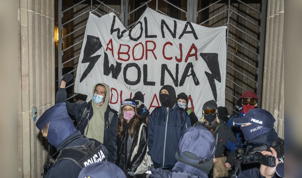 De politie greep maandag in bij een protest van pro-abortusbetogers voor het ministerie van Onderwijs in Warschau. (beeld afp / Wojtek Radwanski)