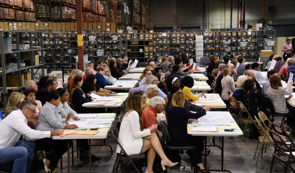 Een van de vele hertellingen van de stemmen in de VS, hier in Palm Beach County in Florida in 2018, waar vrijwilligers toezien op een correcte gang van zaken. (beeld afp / Michele Eve Sandberg)