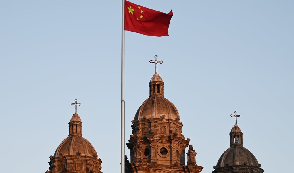 De Chinese vlag voor de Sint-Jozefkerk in Peking, wapperend op 22 oktober 2022, de dag waarop China en het Vaticaan hun akkoord over bisschopswijdingen verlengden. (beeld Greg Baker / afp)