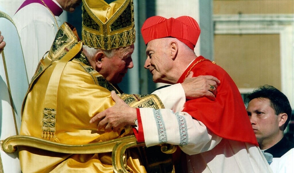 Een foto uit 2001 waarop de voormalige kardinaal Theodore McCarrick (rechts) paus Johannes Paulus II omarmt. (beeld epa)