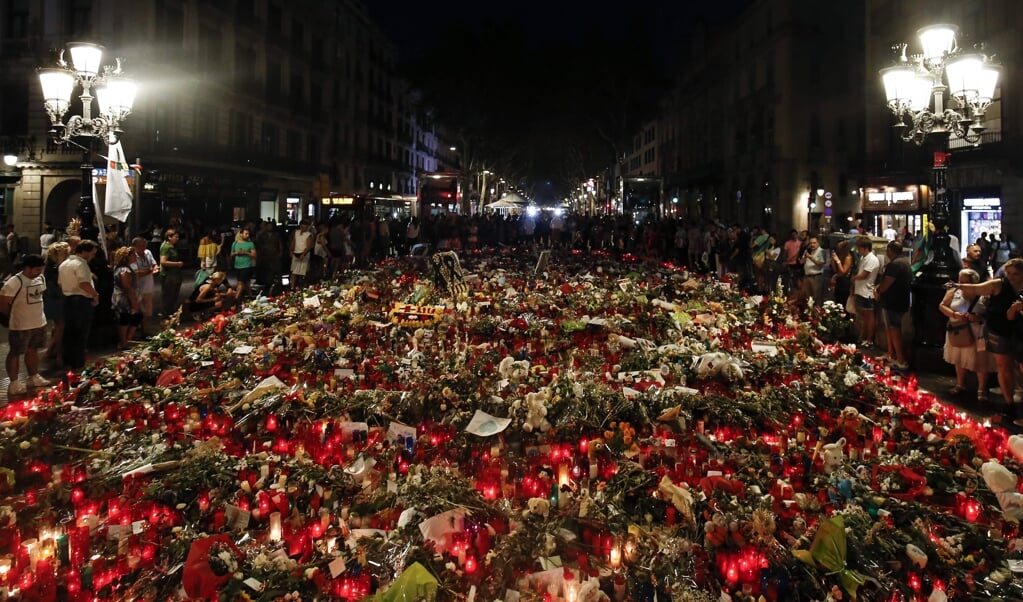 Mensen brengen bloemen, boodschappen en kaarsen om hun medeleven te betuigen met de slachtoffers van de aanslagen in Barcelona en Cambrils, en de nabestaanden. De foto is gemaakt in 2017, kort na de aanslagen. (beeld afp / Pau Barrena)