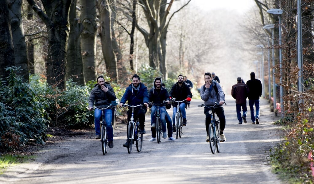 Vluchtelingen houden zich op, wandelen fietsen fiets , bij kamp Heumensoord. (beeld anp / Robin Utrecht)