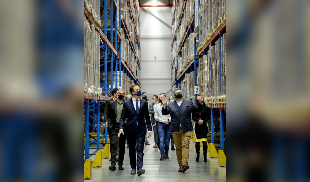 Minister Hugo de Jonge (Volksgezondheid, Welzijn en Sport) wordt rondgeleid door locatiemanager Michiel Heller van Movianto Nederland tijdens een werkbezoek aan de locatie voor opslag van vaccinaties tegen COVID-19. (beeld anp / Robin van Lonkhuijsen)
