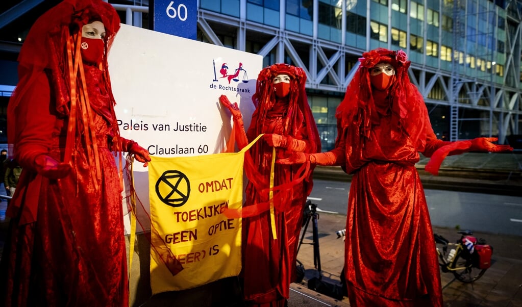 Actievoerders bij de rechtbank waar Milieudefensie samen met zes andere organisaties een zaak heeft aangespannen tegen Shell. (beeld anp / Robin van Lonkhuijsen)