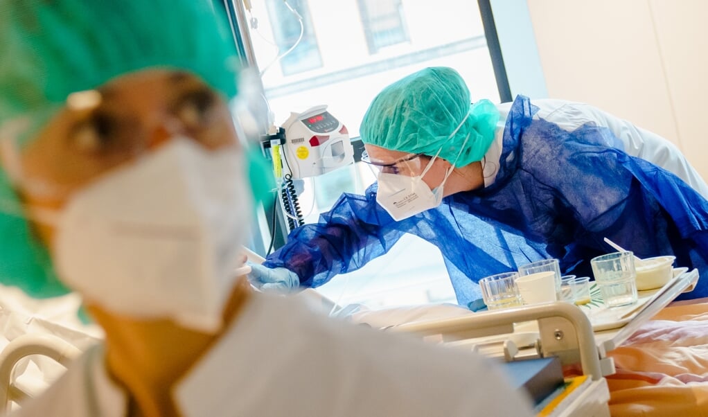 Medewerkers geven zorg aan een coronapatiënt op een speciale afdeling in het Amphia Ziekenhuis in Breda. (beeld anp / Marco de Swart)