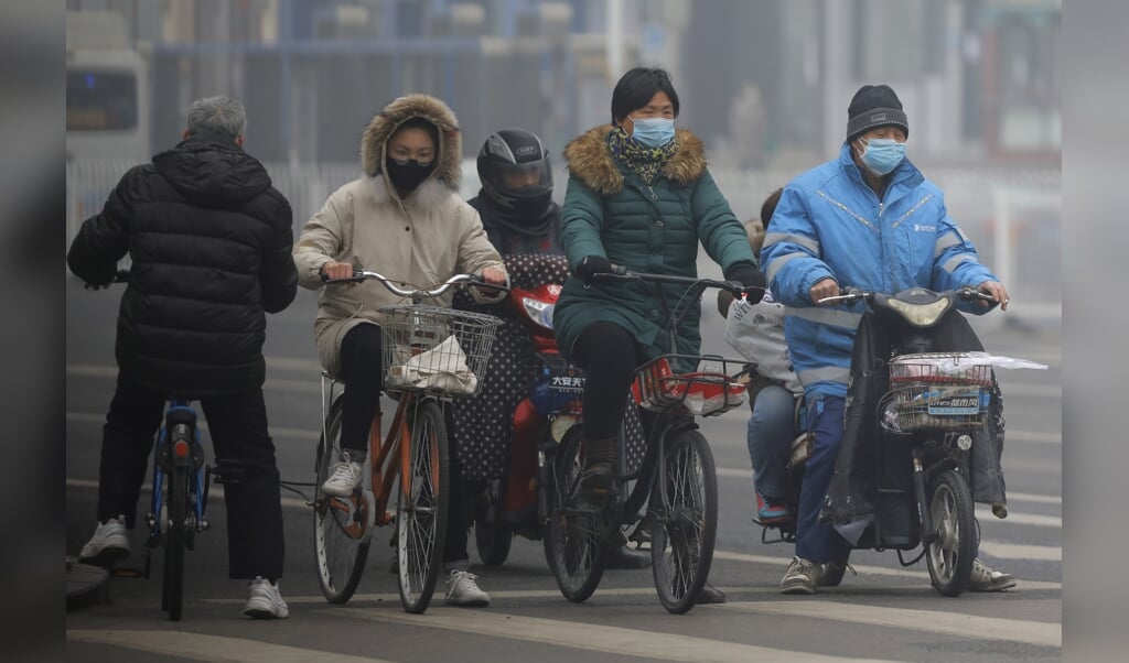 Inwoners van Peking gaan niet naar buiten zonder bescherming tegen het coronavirus. China meldde een sterke toename van het aantal besmettingen. Volgens Russische media zouden de VS achter het virus zitten. (beeld epa / Wu Hong)