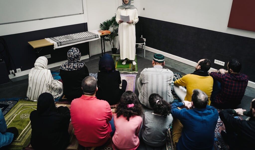Imame Kahina Bahloul gaat voor tijdens het islamitische gebed, met een gemengd publiek. (beeld afp / Lucas Barioulet)