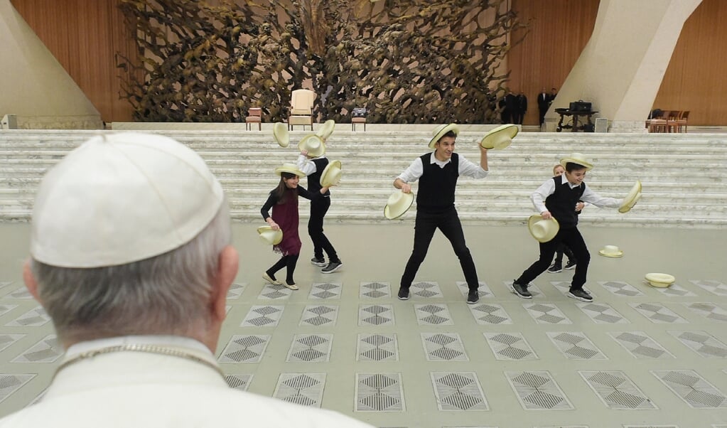 De paus kijkt naar een voorstelling tijdens een audiëntie in het Vaticaan eerder deze maand. (beeld epa / vaticaan media)