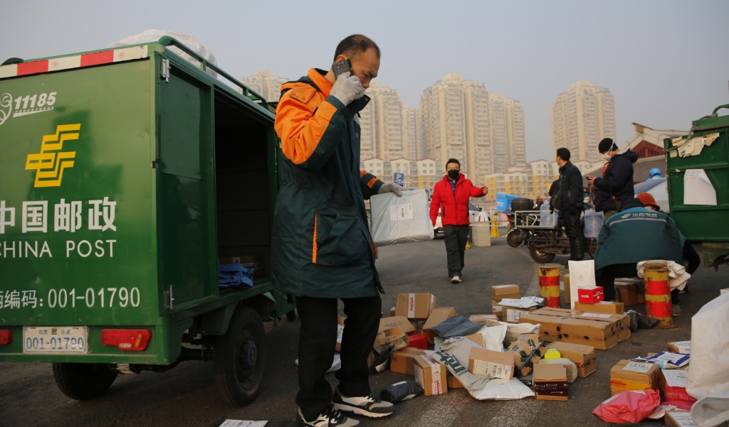 Een koeriersbedrijf levert mondkapjes in Peking, ter bescherming van het nieuwe coronavirus. (beeld Epa / Wu Hong)