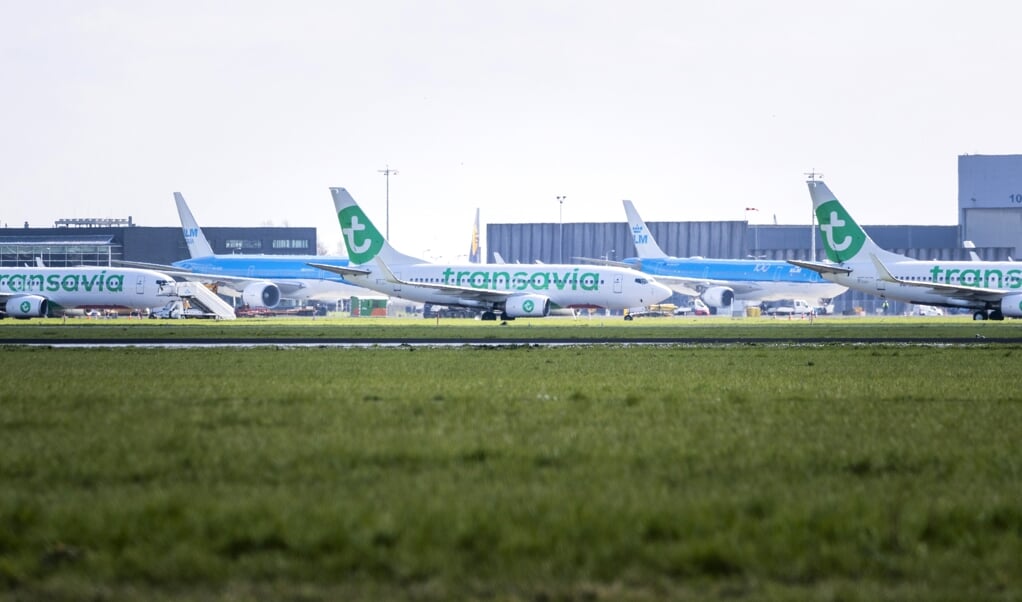 Vliegtuigen blijven aan de grond op Schiphol. Als deze crisis voorbij is, mag de luchtvaart wel wat meer gaan betalen voor kerosine. (beeld anp / Remko de Waal)