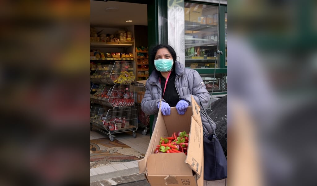 Een verkoper op de Naschmarkt in Wenen. In Oostenrijkse supermarkten zijn mondkapjes verplicht. (beeld afp )