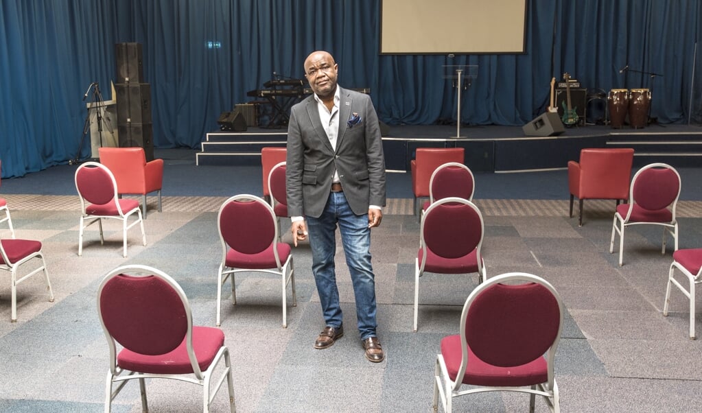 Pastor Nana Baiden in zijn kerk. Nu collecte-inkomsten door de coronacrisis uitblijven, kan de hypotheek niet meer betaald worden. (beeld Martin Waalboer)