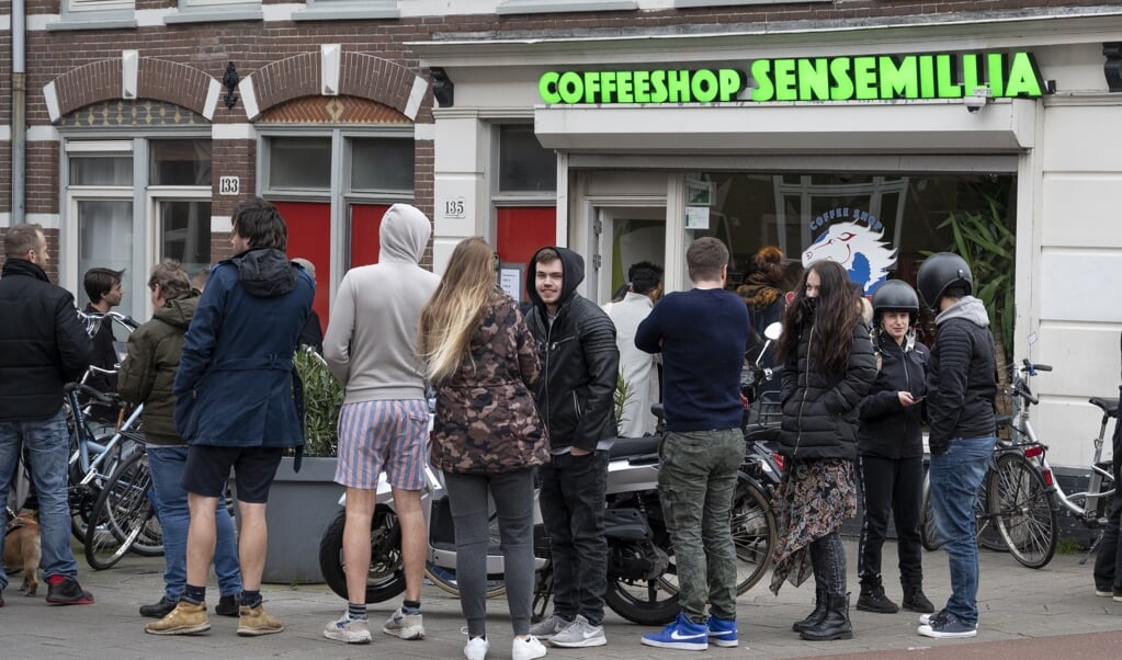 Drukte bij een coffeeshop op zondagavond 15 maart. Het kabinet maakte die dag bekend dat alle horeca om 18.00 uur moest sluiten. (beeld anp / Evert Elzinga)
