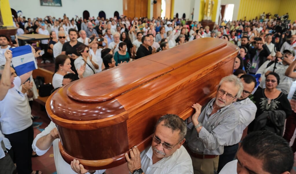 De doodskist van de overleden dichter en priester Ernesto Cardenal wordt de kathedraal van Managua binnengedragen. (beeld afp / Inti Ocon)