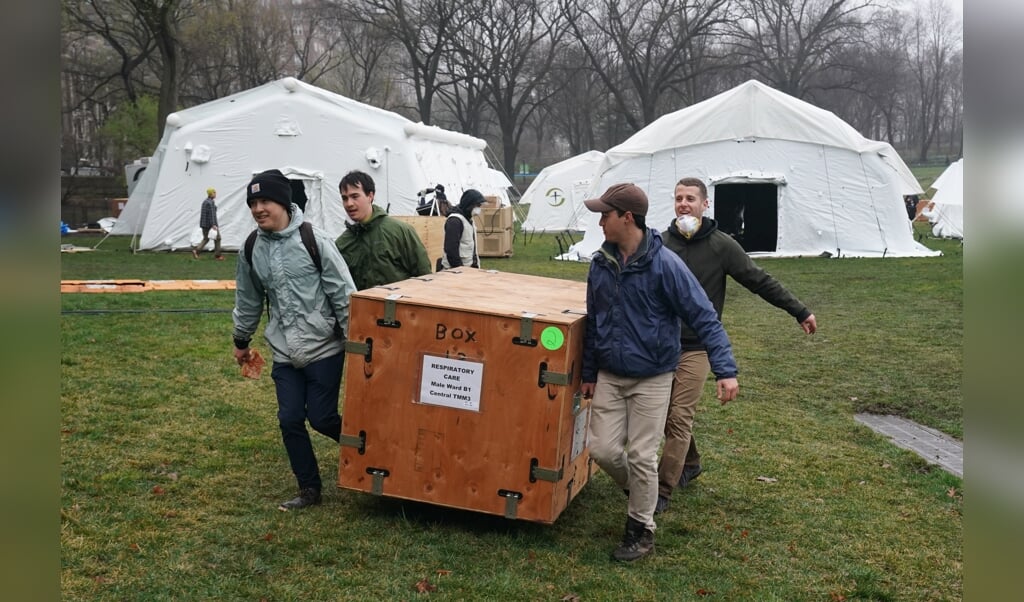 Medewerkers van de christelijke organisatie Samaritan’s Purse zetten zondag nabij een ziekenhuis in New York een noodhospitaal op. (beeld epa / Bryan Smith)