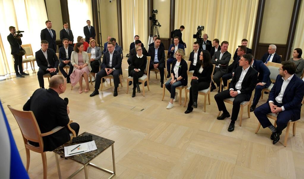 De Russische president Putin luistert naar Anastasia Tatulova (derde van rechts), eigenaresse van de gezinsvriendelijke cafetariaketen ‘Fabriek van geluk’. (beeld kremlin)