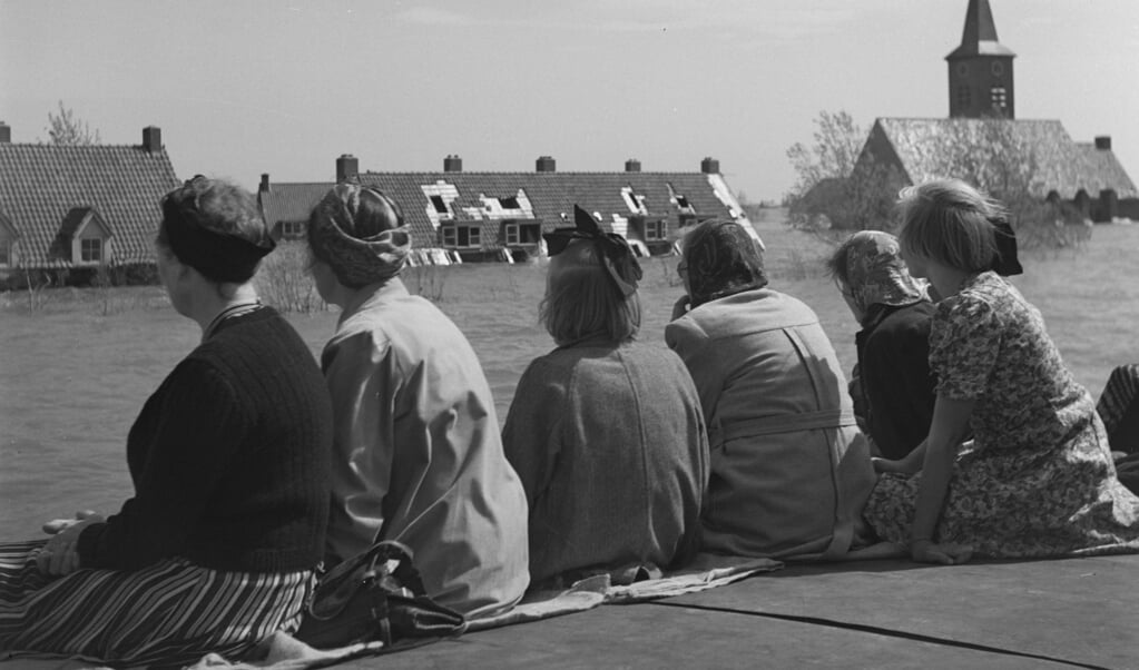 Vanaf een schip kijken vrouwen naar het dorp Middenmeer in de Wieringermeer, mei 1945. (beeld Willem van de Poll / anefo)